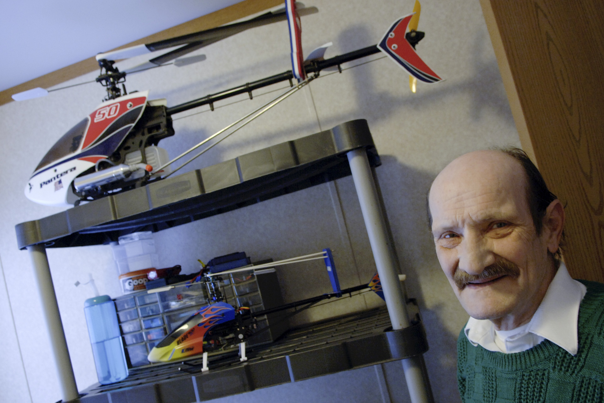 Man stands in room with model airplanes behind him