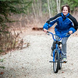 Adolescent riding a bicycle along a trail
