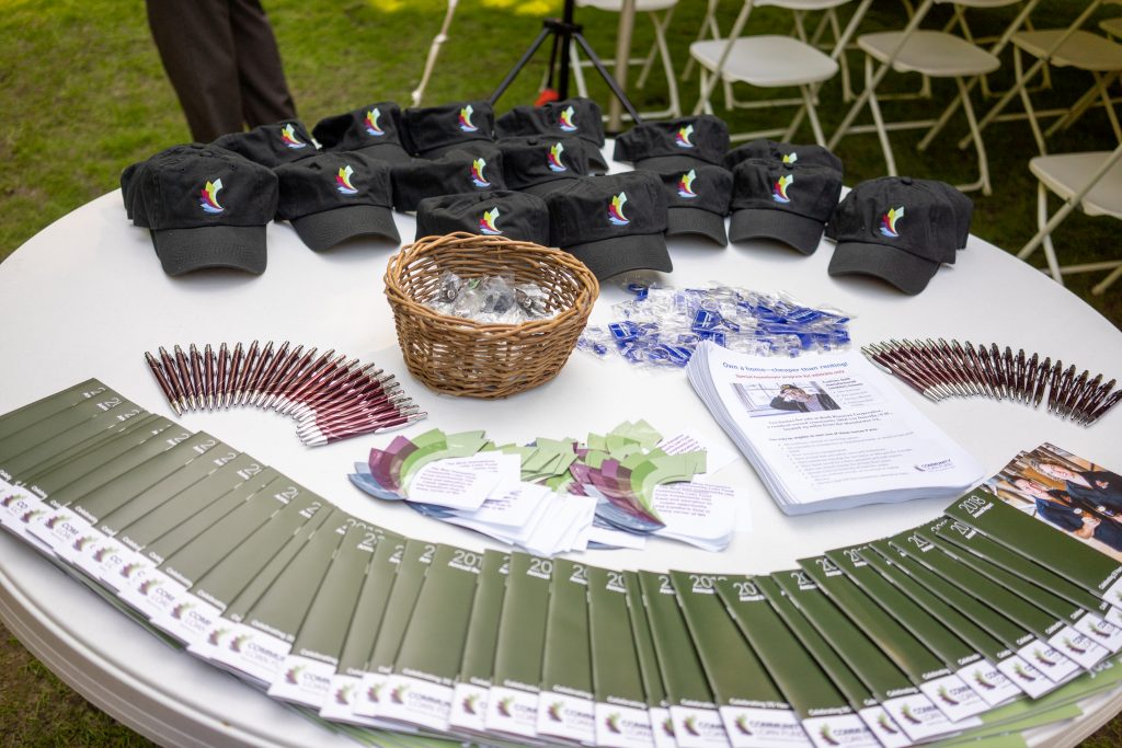Giveaway items--hats, magnets, and annual reports--spread out on table