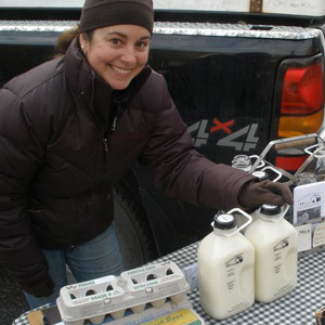 Sarah Costa selling milk and eggs at a farmer's market